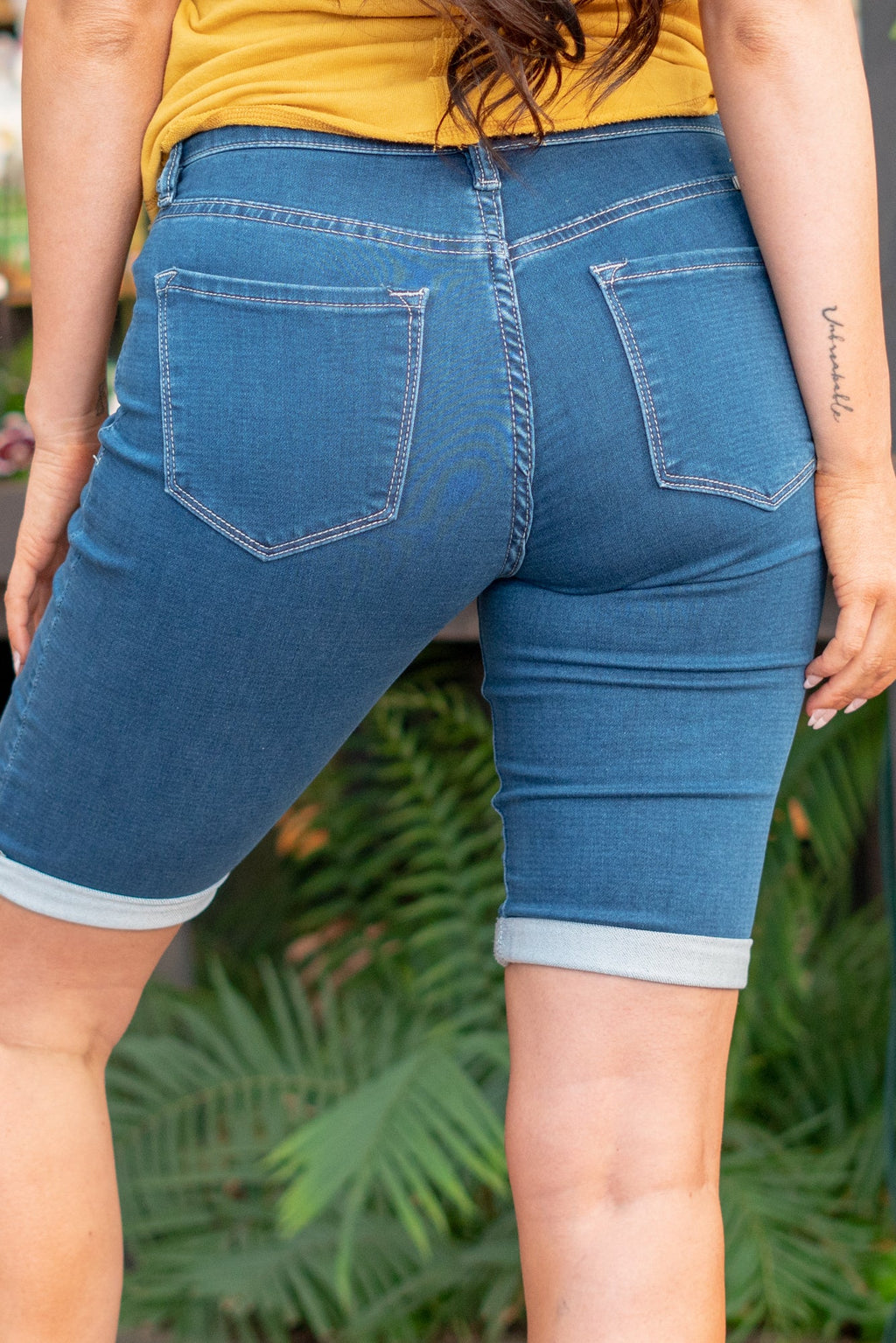 KanCan Jeans Color: Medium Blue Wash Cut: Bermudas, 11" Inseam* Rise: Mid-Rise, 9" Front Rise* 66% COTTON, 33% POLYESTER, 1% SPANDEX Stitching: Classic  Fly: Zipper Fly Style #: KC20005M Contact us for any additional measurements or sizing.  *Measured on the smallest size, measurements may vary by size.  Jacquelyn wears a size 25 in jeans, a small in tops, and 6.5 in shoes. She is wearing a size 25 in these shorts.